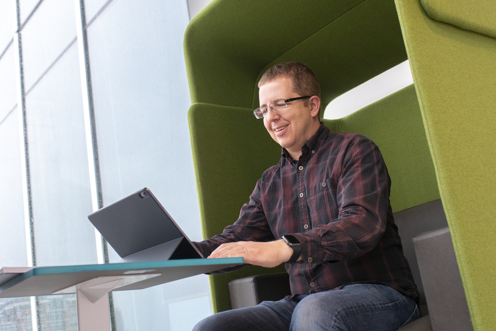 Tech employee sitting with their laptop