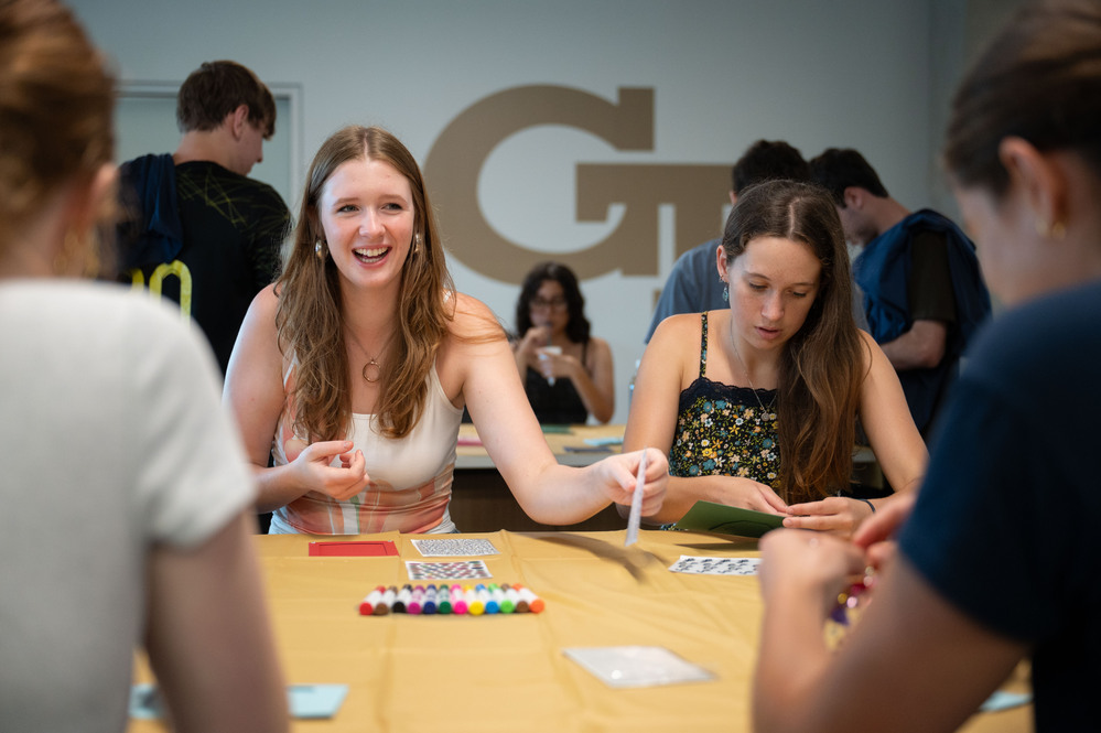students sitting at a table and one person is smiling
