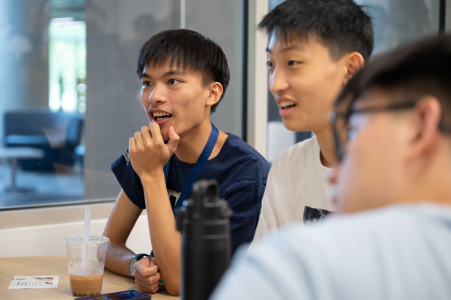 3 students sitting around a table chatting